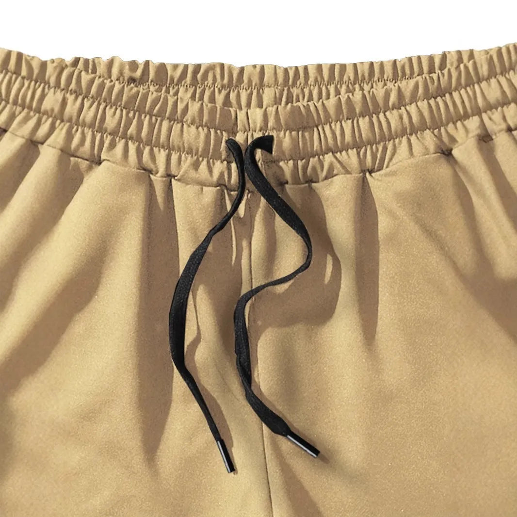 A pair of khaki men's casual shorts featuring a coconut print, shown in a straight-leg sports style.