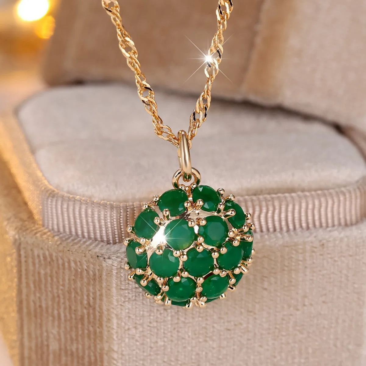 Round pendant necklace with emerald diamond elements on champagne gold electroplated chain