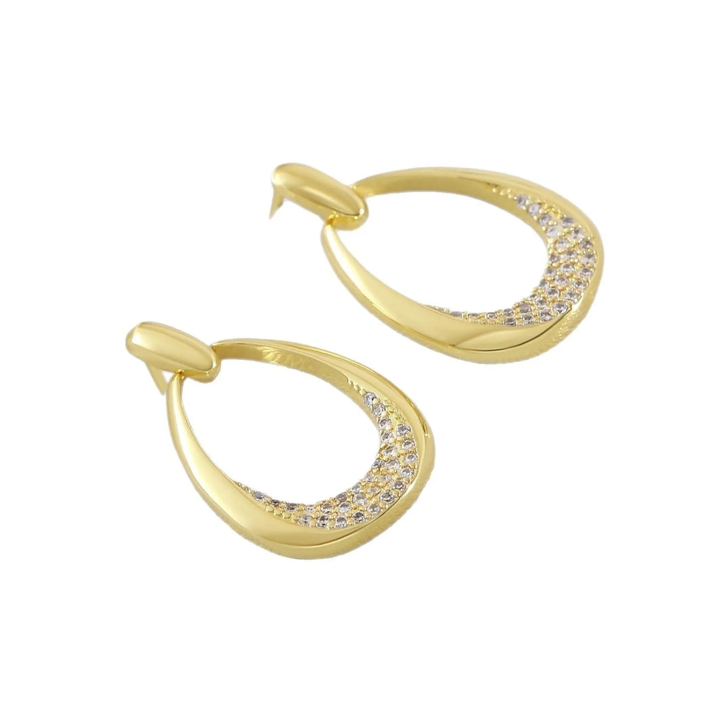 Women's yellow gold geometric drop-shaped earrings with ring design and zircon accents on a white background.