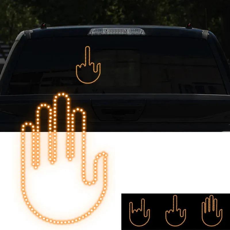 Black plastic LED car gesture light showing illuminated middle finger sign on dashboard