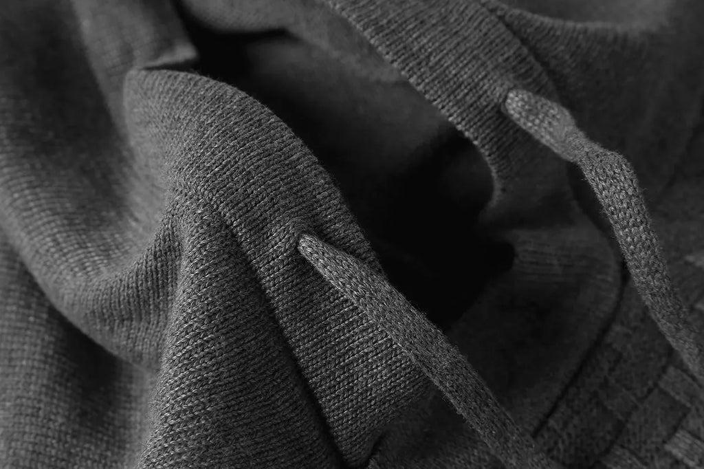 Man wearing a grey cotton-polyester blend hooded sweatshirt, showcasing the casual hoodie design.