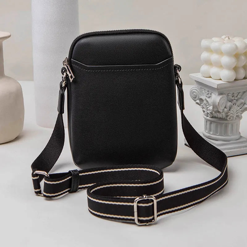 Black PU mobile phone bag with crossbody strap showing shoulder carry option