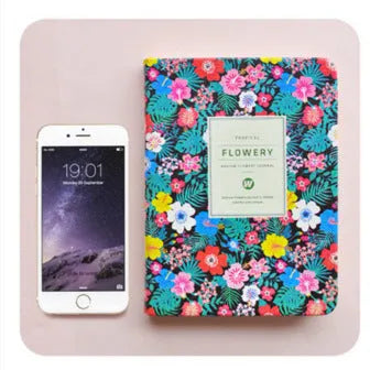 Green floral notepad with imitation leather cover lying open, showing lined Daolin paper.