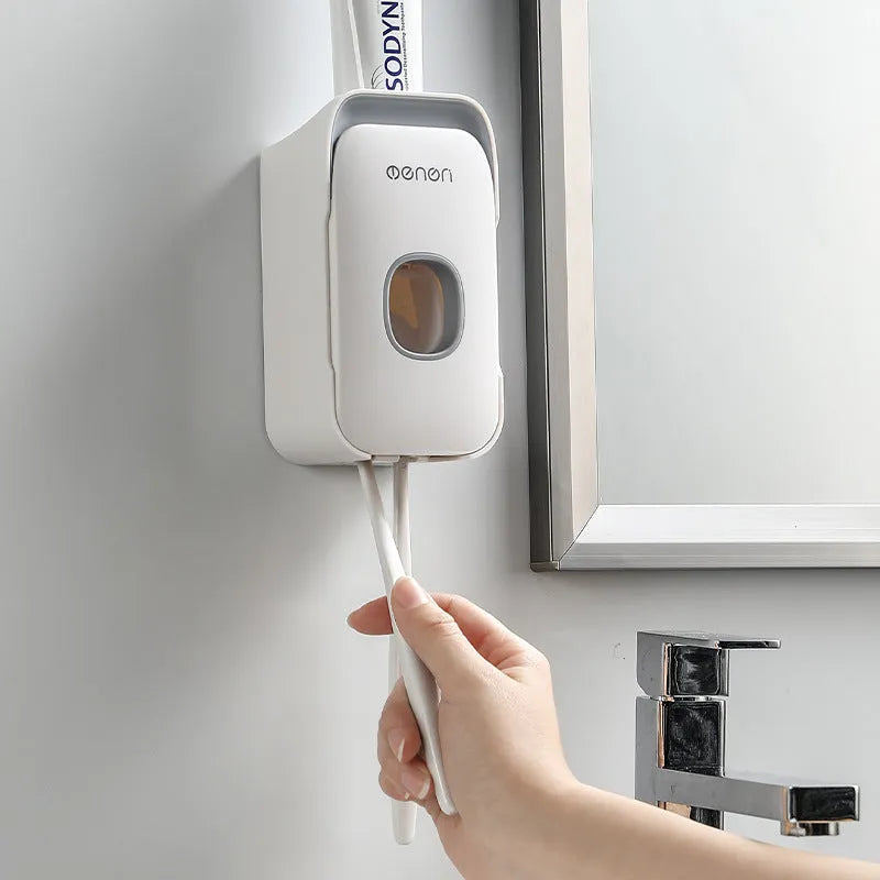 Automatic toothpaste dispenser in ABS plastic with suction cup wall mount in blue, grey, and pink colour options