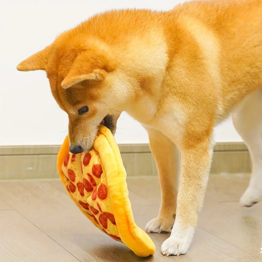 Yellow pizza slice shaped plush squeaky dog chew toy on a white background