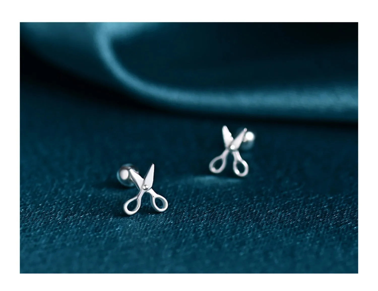 A pair of pure silver screw-style ear nails featuring a miniature scissors charm.