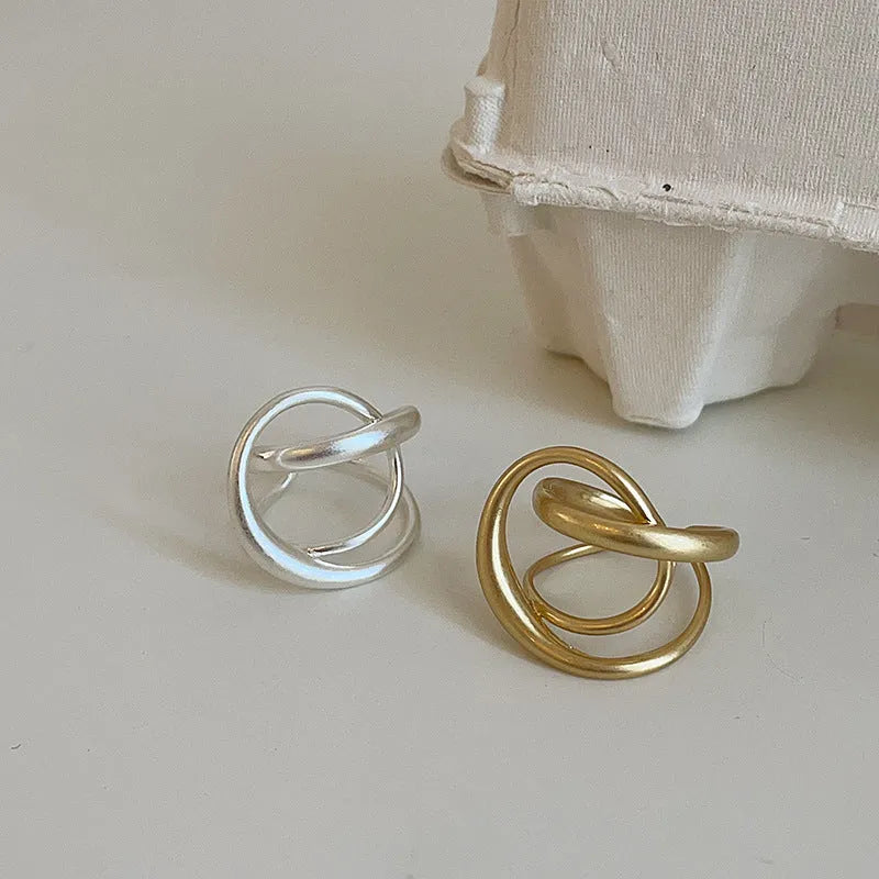 Geometric open ring with three-dimensional interlaced metal and matte electroplated finish in gold or silver colour