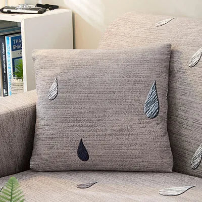 Geometric patterned stretch sofa slipcover fitted on a three-seater sofa in a living room.