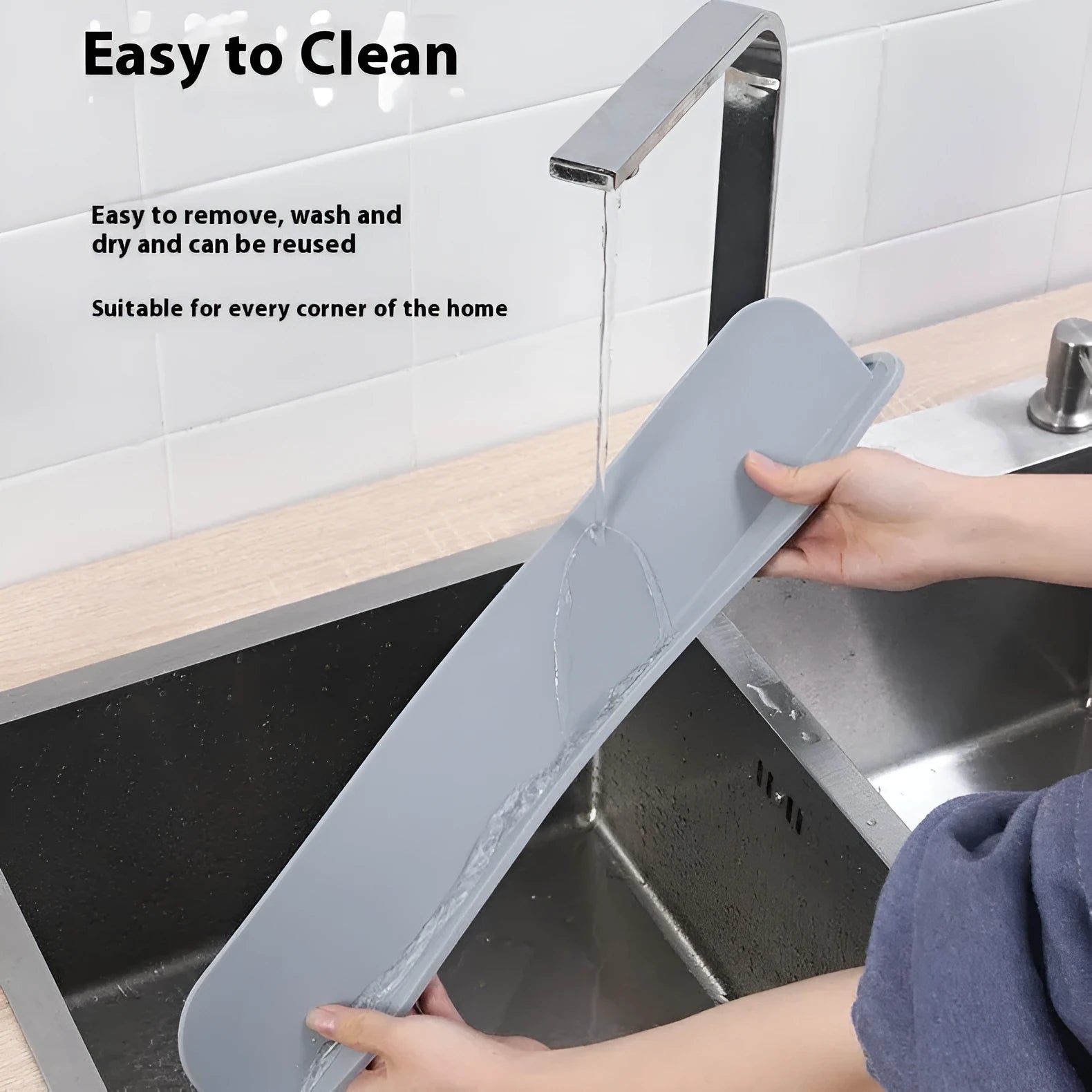 Grey silicone sink water blocking plate placed behind a kitchen tap