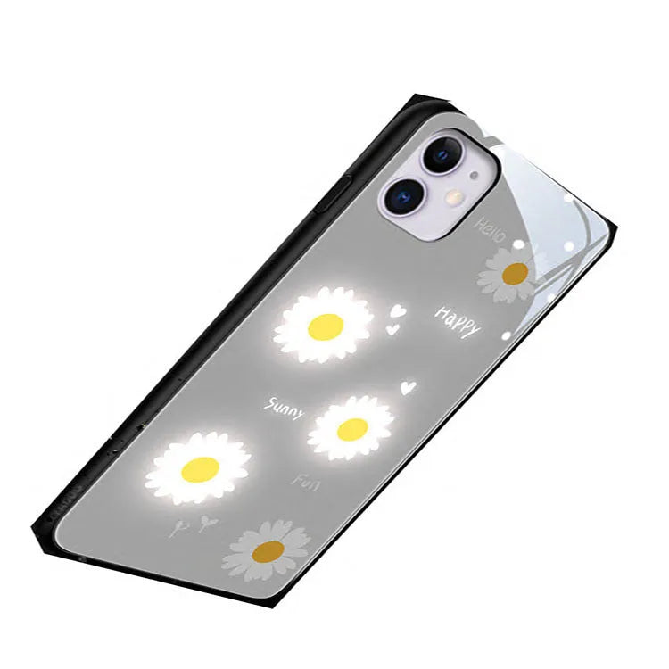 White voice-activated LED iPhone case with painted daisy and letter design, showing colour-changing lights.