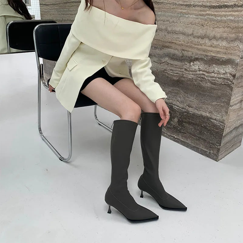 Black women's pointed toe below knee boots with a stiletto heel and a back zip fastener.