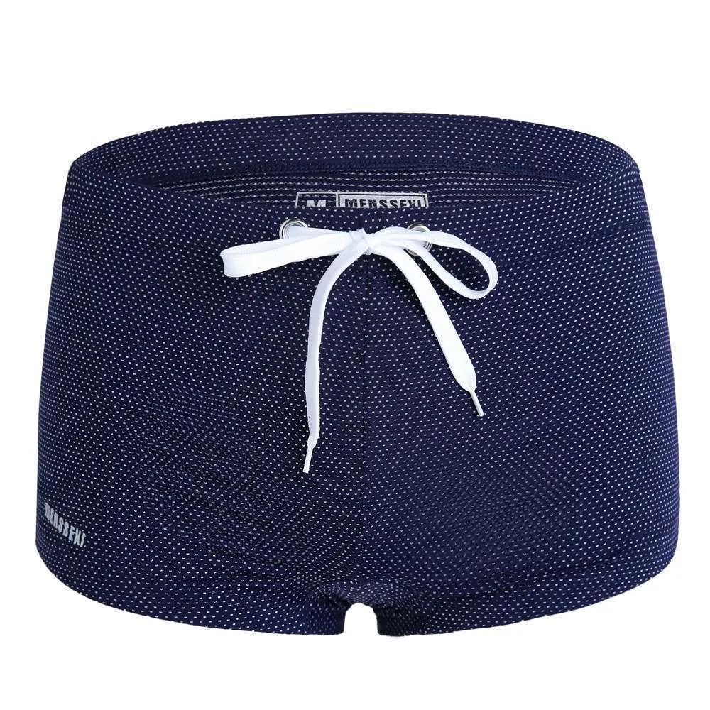 Men's solid colour nylon boxer swimming trunks with a low waist design on a white background.