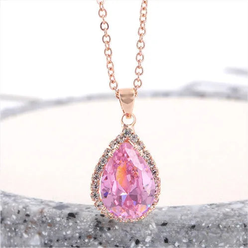 Women's geometric drop shape pendant necklace with rhinestone detail in pink electroplated finish.
