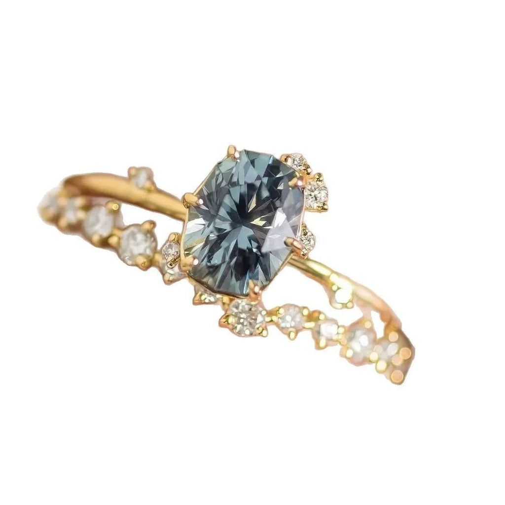 Gold plated flower-shaped ring with inlaid green zircon stones on a white background.