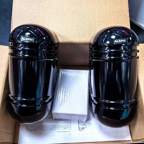 A pair of black infrared beam detectors for long-range perimeter security alarm systems.