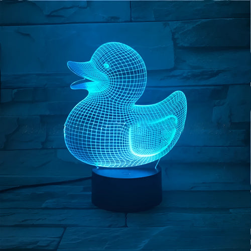 Yellow 3D duck-shaped LED night light on a table with remote control, showing multi-colour glow.