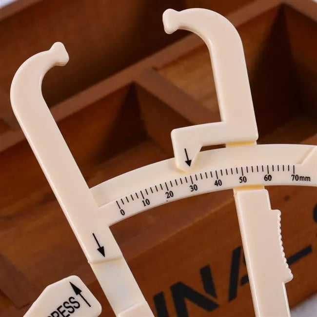 Clear acrylic body fat caliper showing measurement scale up to 200mm with sebum clamp design