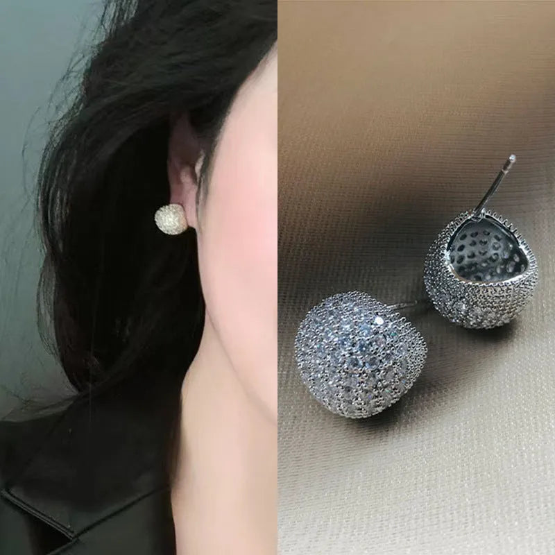 Drop-shaped geometric sphere earrings with full diamond design and little golden beans details in gold colour