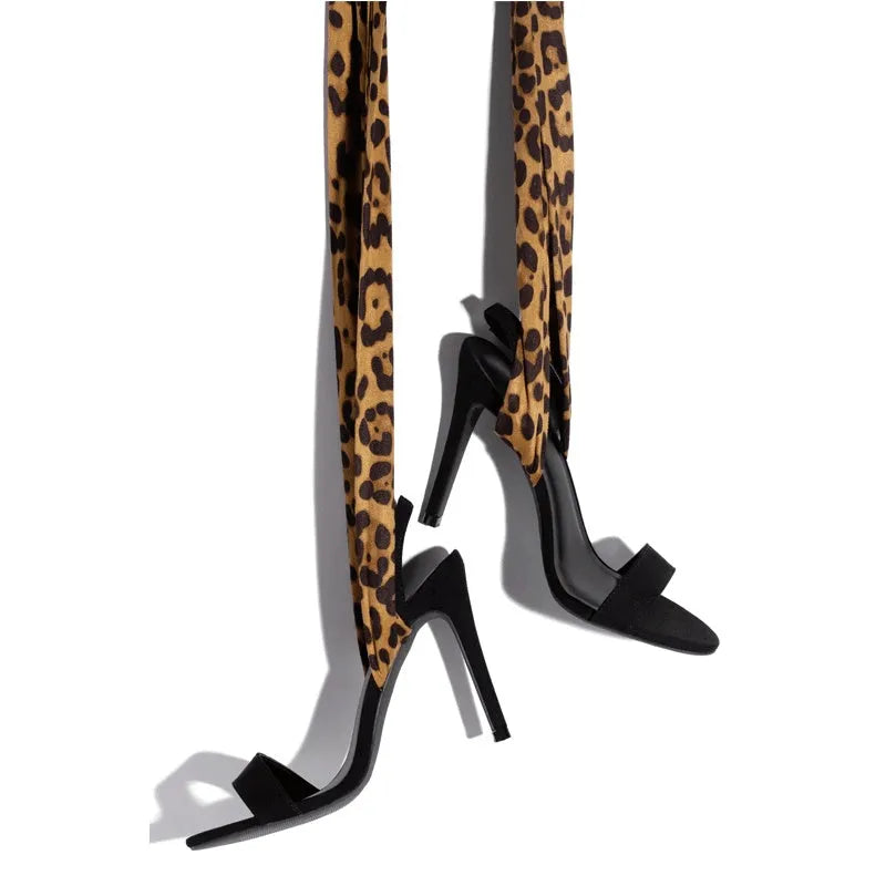 Light brown leopard print women's high heel sandals with cross straps and a tall thin heel.