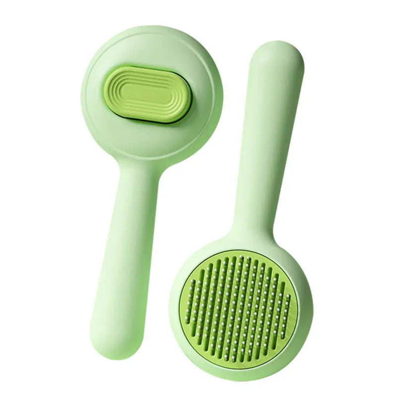Green and yellow cat grooming brush with stainless steel comb and non-slip handle on a white background.