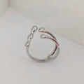 Gold and silver coloured brass opening ring with spherical design on a white background.