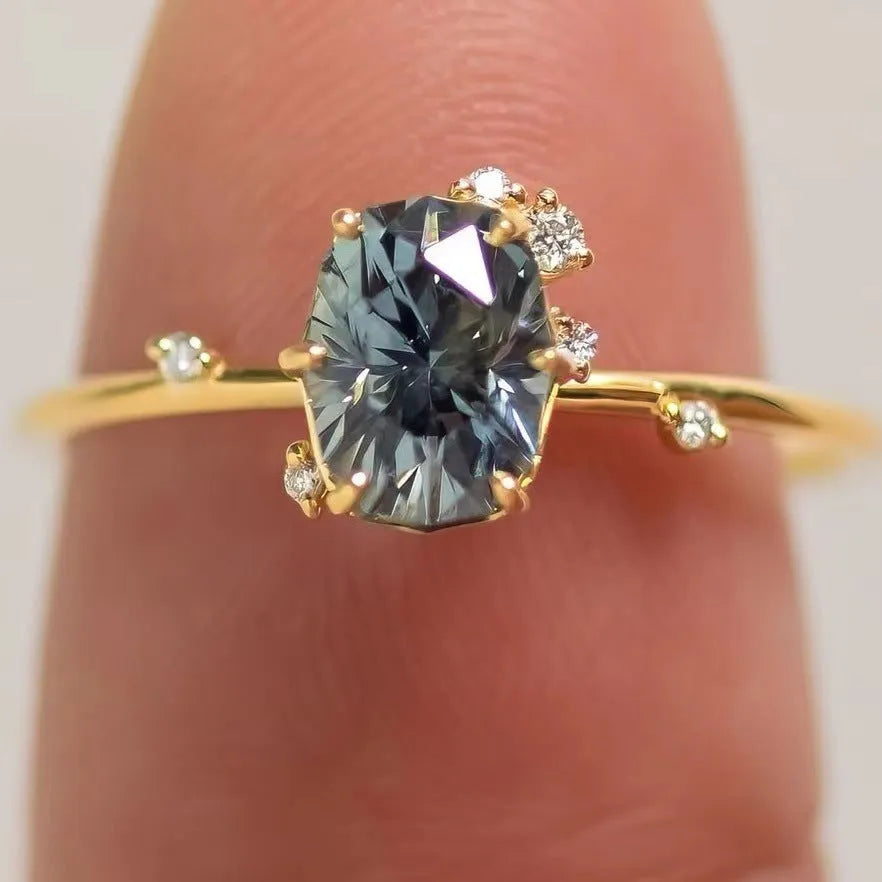 Gold plated flower-shaped ring with inlaid green zircon stones on a white background.