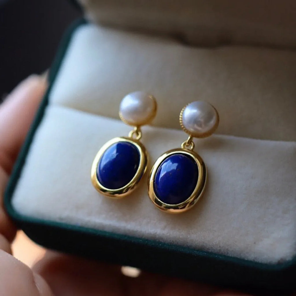 A pair of simple sterling silver earrings featuring a blue lapis lazuli pearl and auspicious patterns.