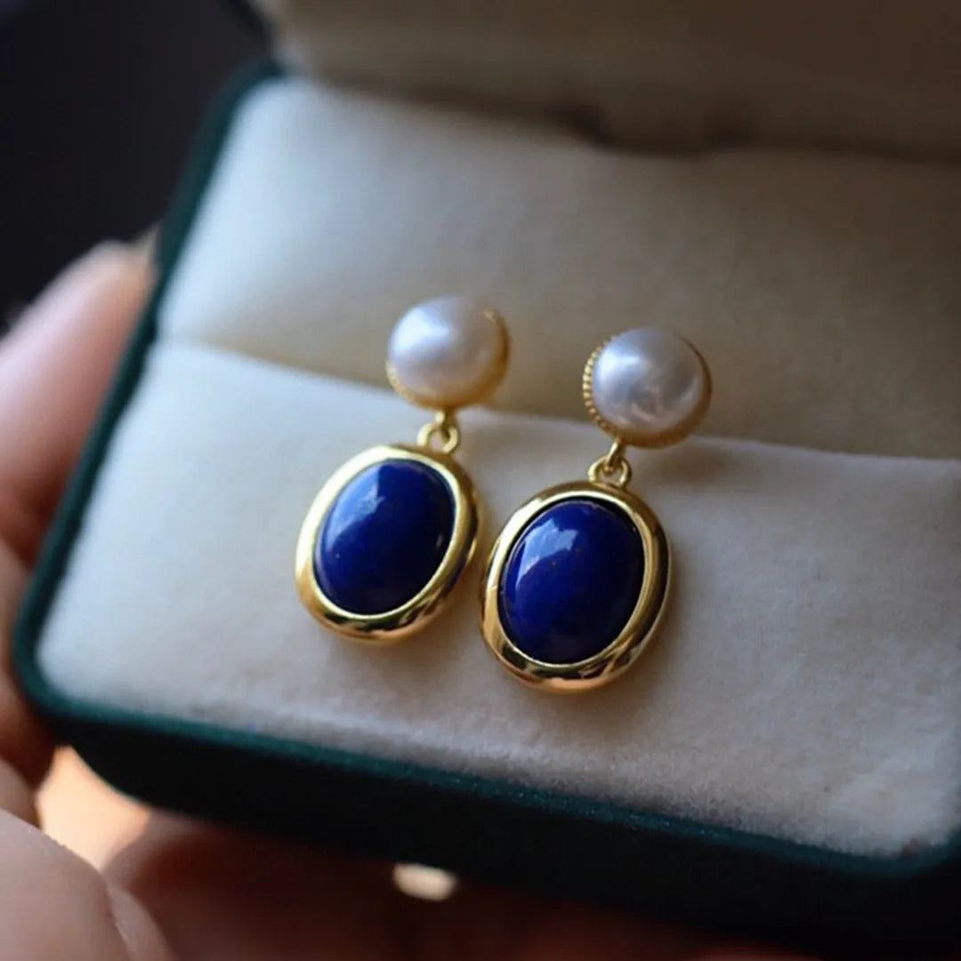 A pair of simple sterling silver earrings featuring a blue lapis lazuli pearl and auspicious patterns.