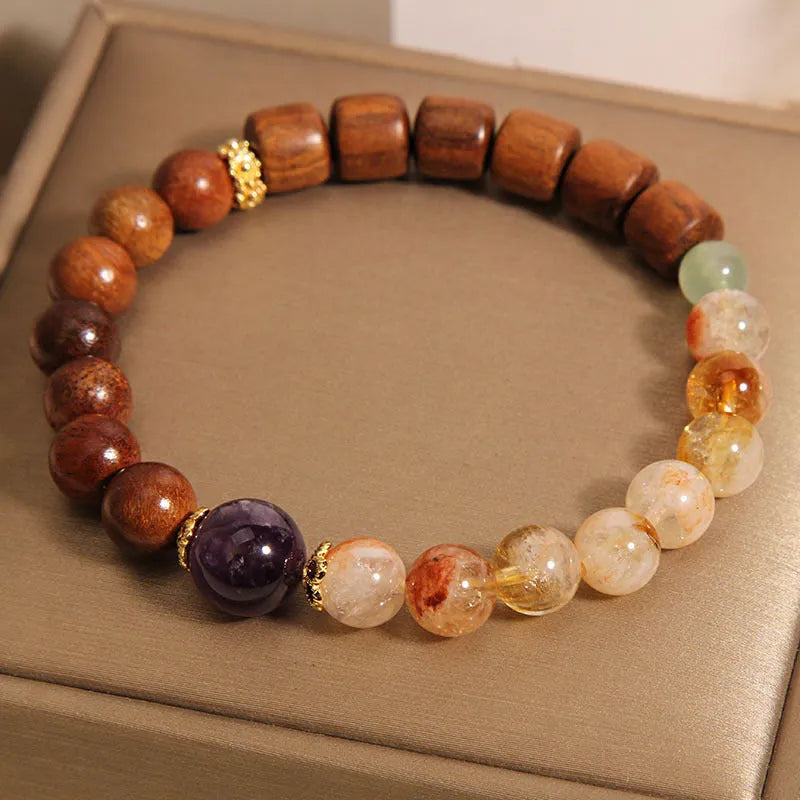 Women's bracelet with yellow crystal, amethyst, ebony, pearls, and rhinestones.