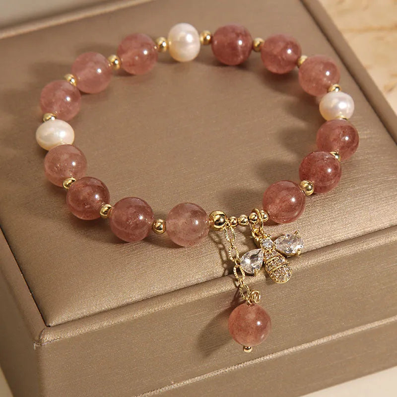 Women's freshwater pearl and strawberry quartz bracelet with zircon accents on wrist