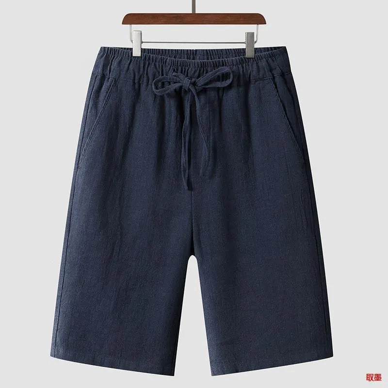 Man wearing beige linen casual shorts with a loose, cropped fit and elasticated mid waist.