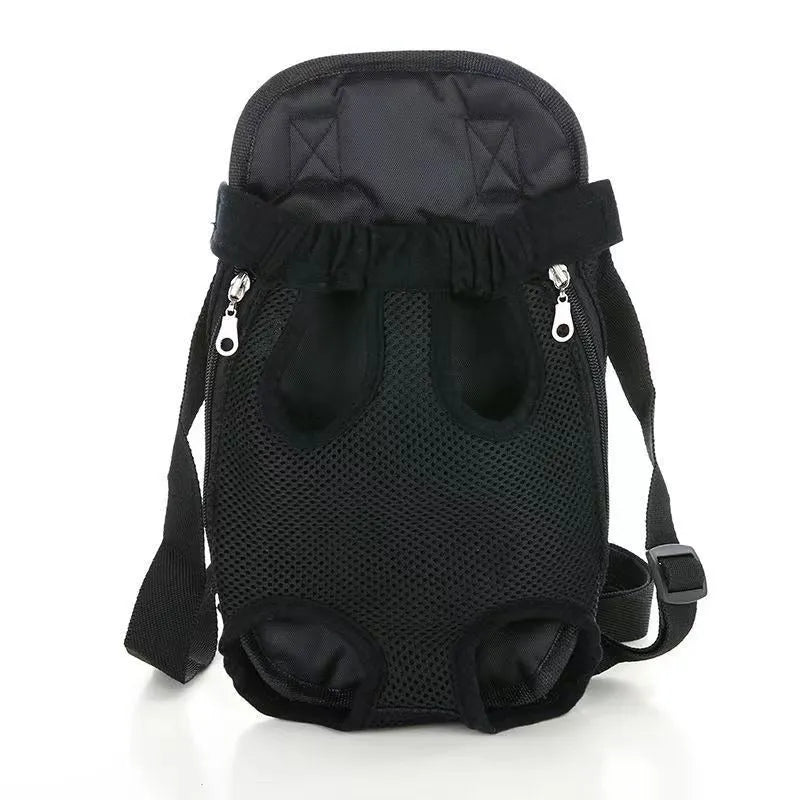 A person wearing a black nylon dog carrier backpack on their chest, with a small dog inside looking out.