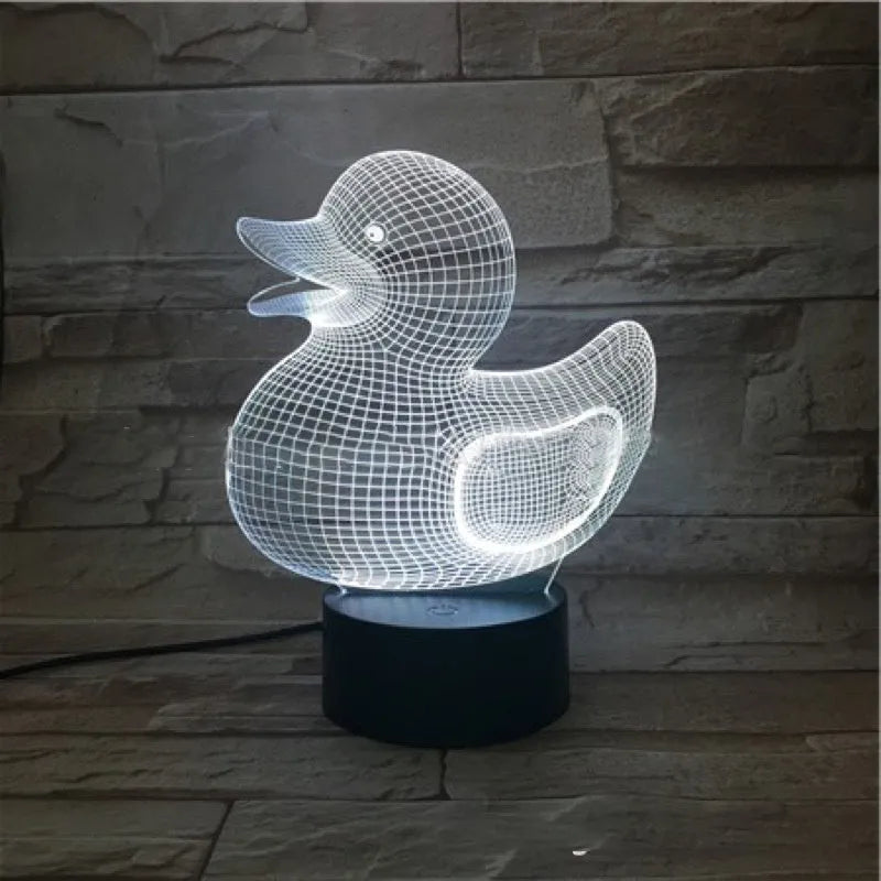 Yellow 3D duck-shaped LED night light on a table with remote control, showing multi-colour glow.