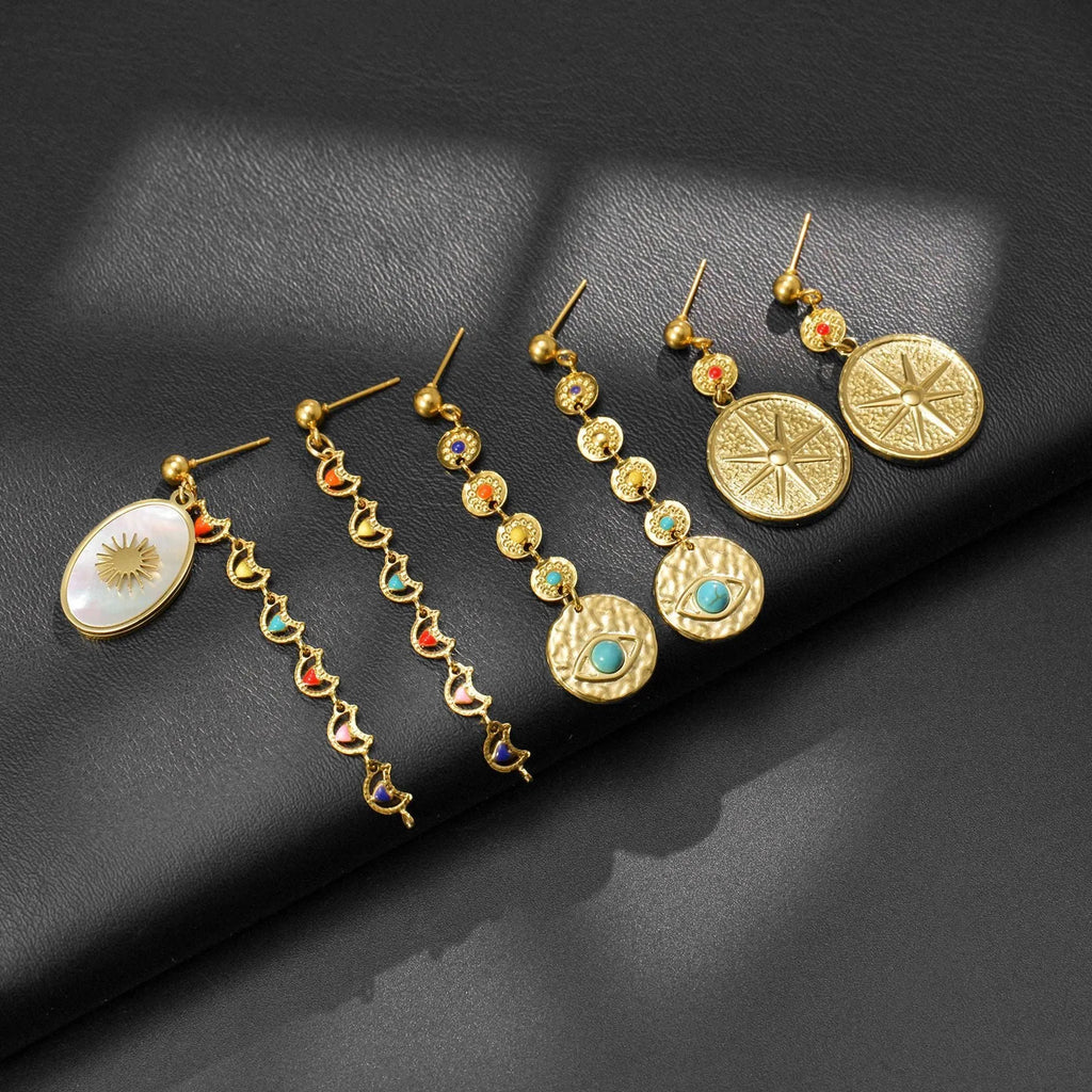 Geometric stainless steel stud earrings showing three colour options: Eight Awn XINGX, Eye, and Shell Sun designs.