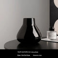 Ceramic round belly decorative vase with coloured glaze and artificial flowers in black or white