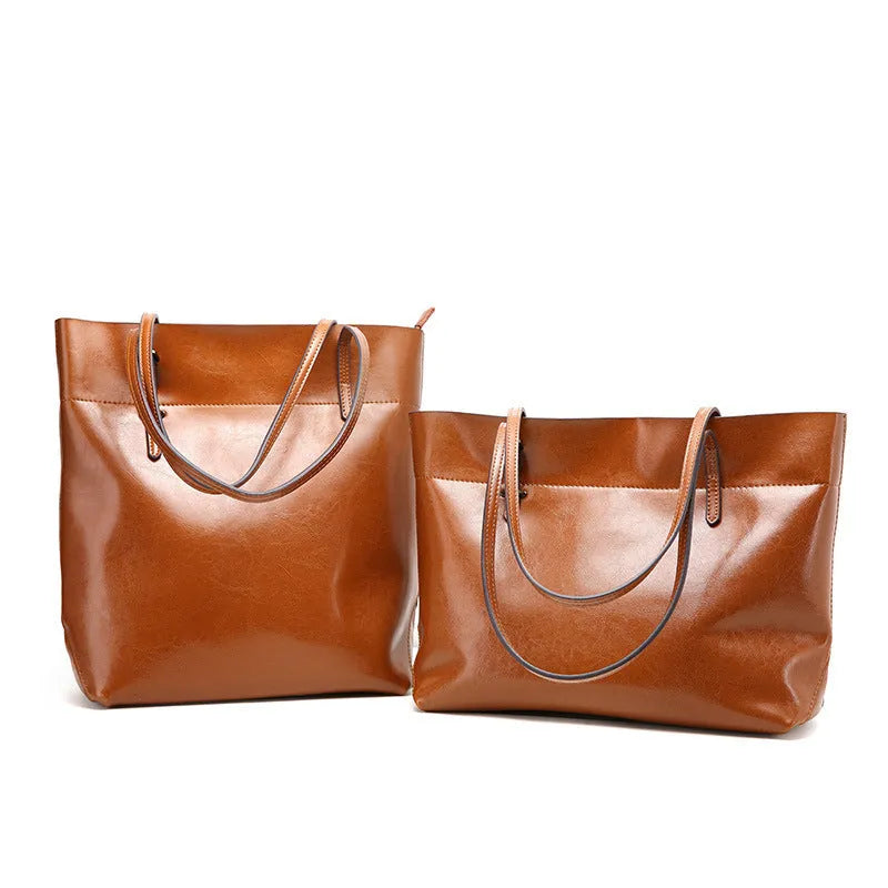 Brown leather crossbody handbag showing two main compartments and a front phone pouch