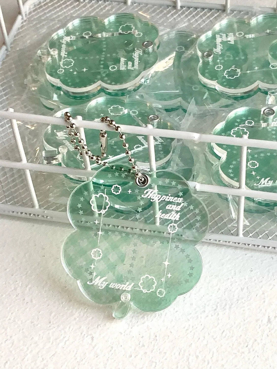 Blue four-leaf clover acrylic charm on a keychain ring.