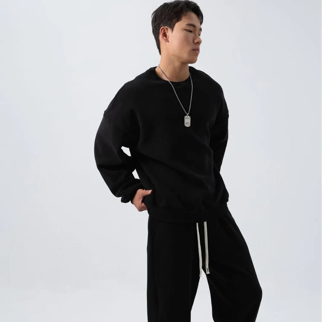 Man wearing a grey polar fleece crew neck coat and matching padded trousers from a casual winter sport suit set.