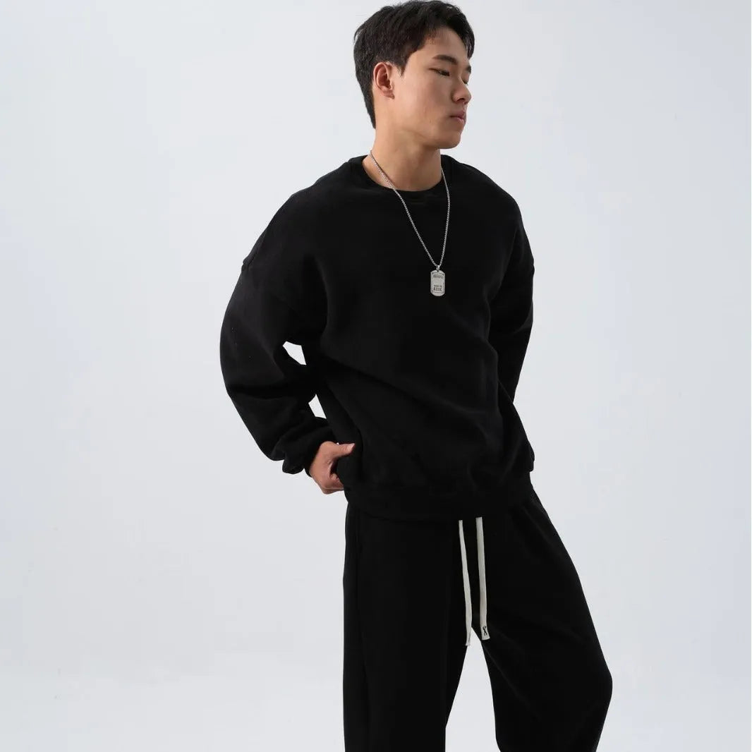 Man wearing a grey polar fleece crew neck coat and matching padded trousers from a casual winter sport suit set.