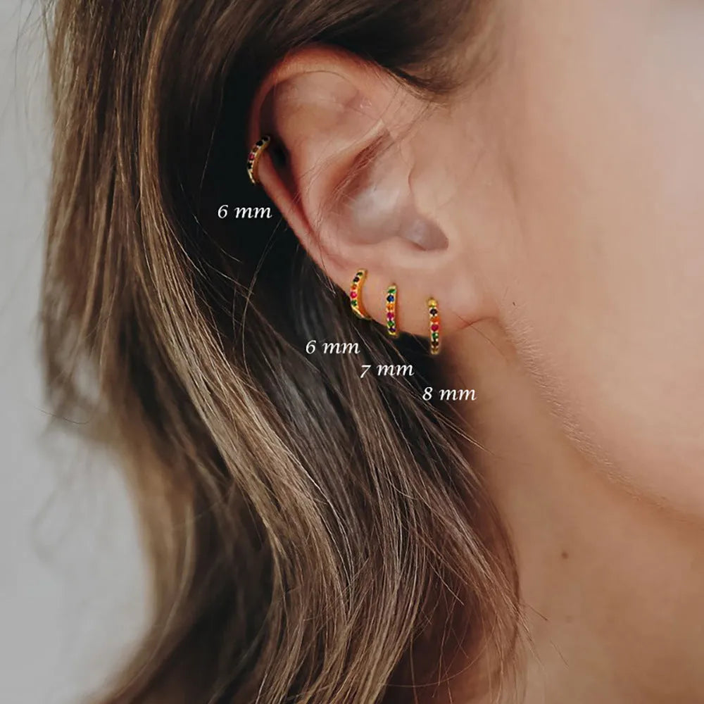 Gold, rose gold, and silver circle stud earrings with a perforated geometric design in various sizes.