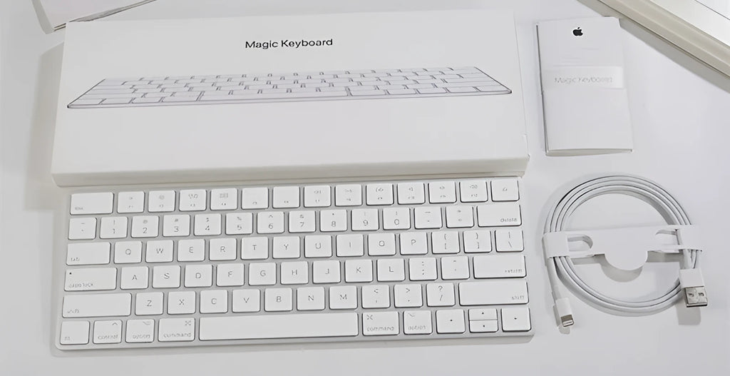 White Apple Bluetooth wireless keyboard with ultra-thin metal casing on a desk.