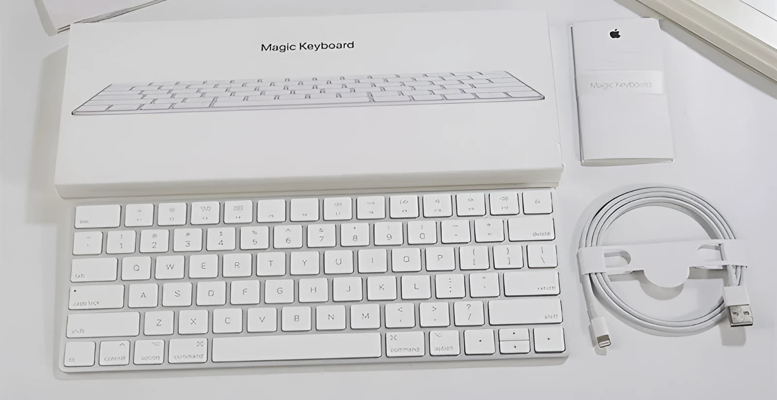 White Apple Bluetooth wireless keyboard with ultra-thin metal casing on a desk.