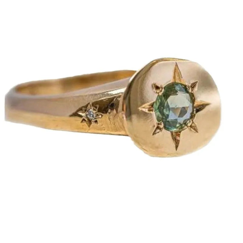 Golden star-shaped ring with oval zircon stone and adjustable band.