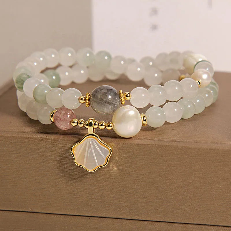 Women's crystal bracelet with a gold-plated ginkgo leaf pendant and rhinestone details.