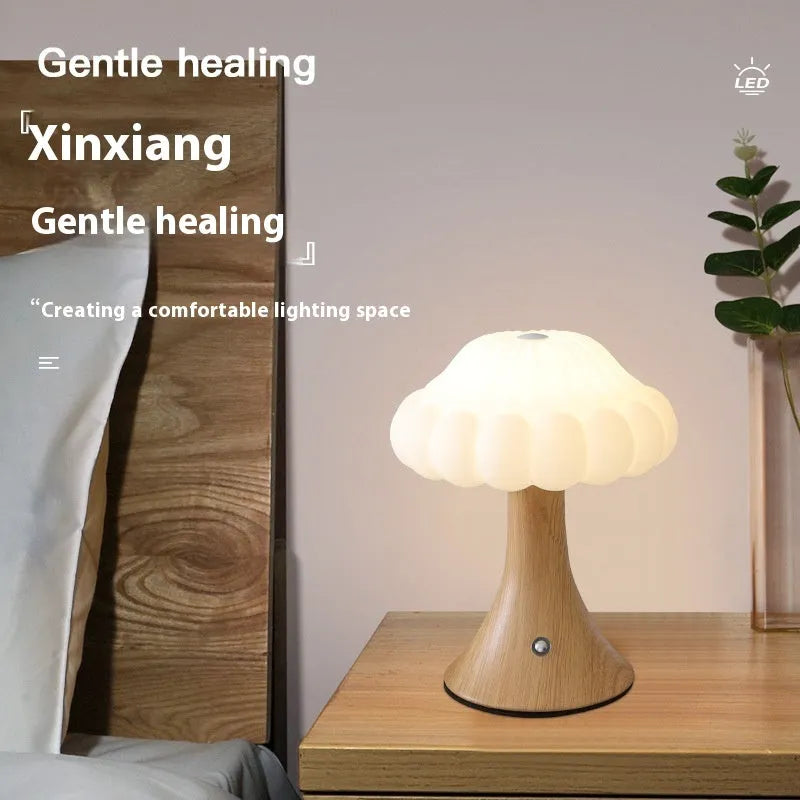 Wood grain coloured mushroom-shaped touch control night light on a wooden surface.