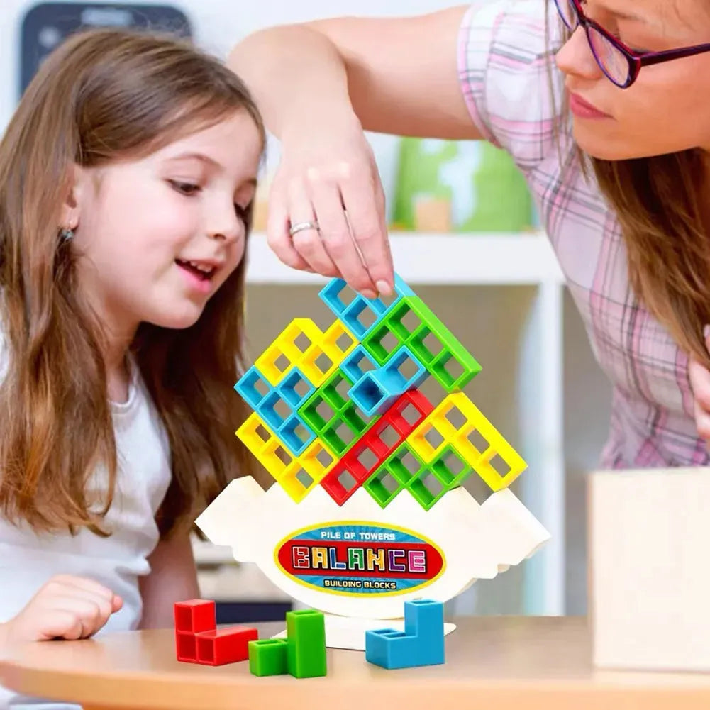Plastic balance stacking board game with 16 colourful building blocks, a chassis, and a base on a flat surface.