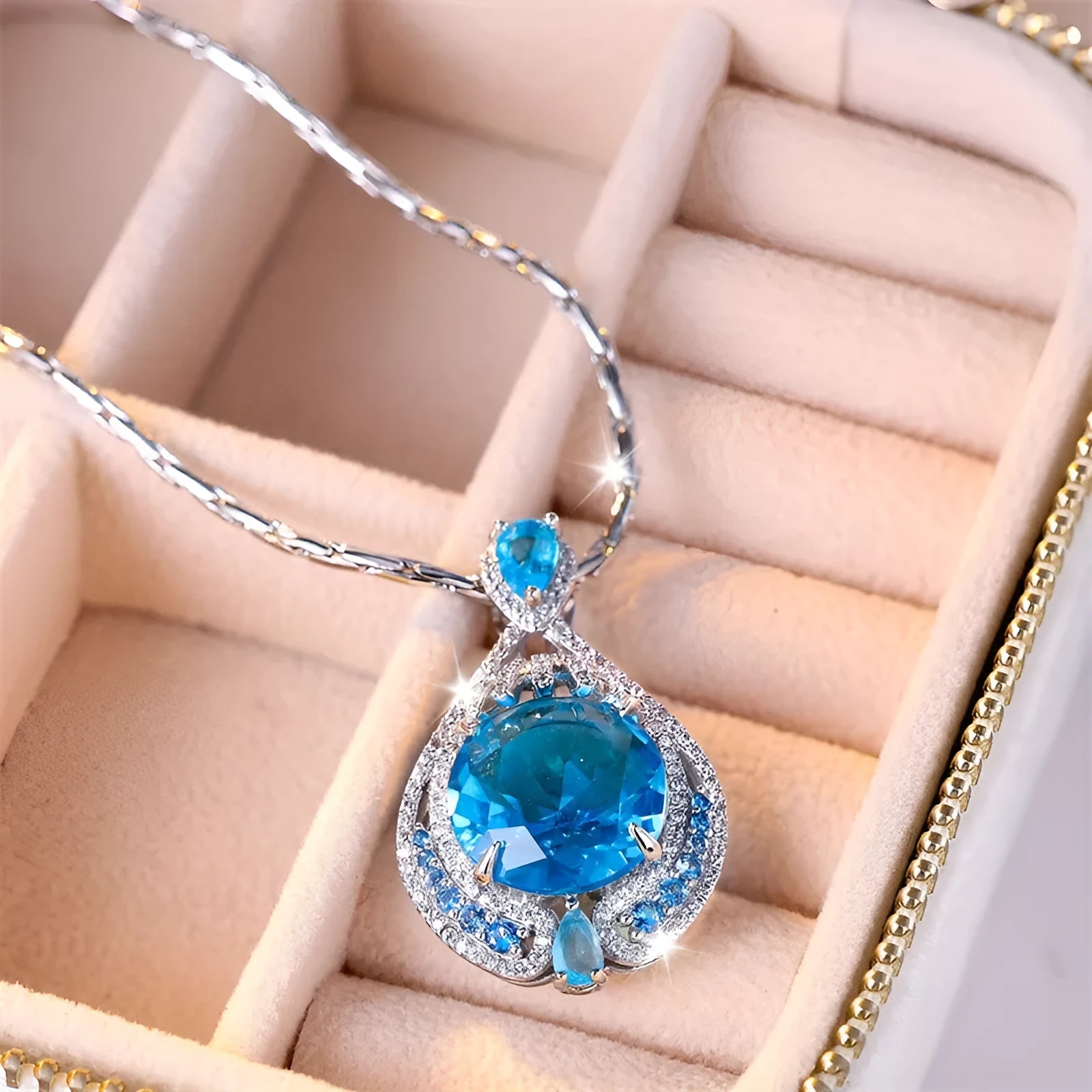 Blue geometric crystal pendant necklace on a water wave chain for women.