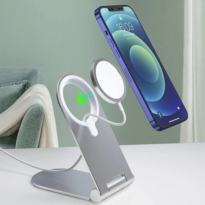 Silver portable magnetic bracket for iPhone 12, showing adjustable vertical stand on a desk.