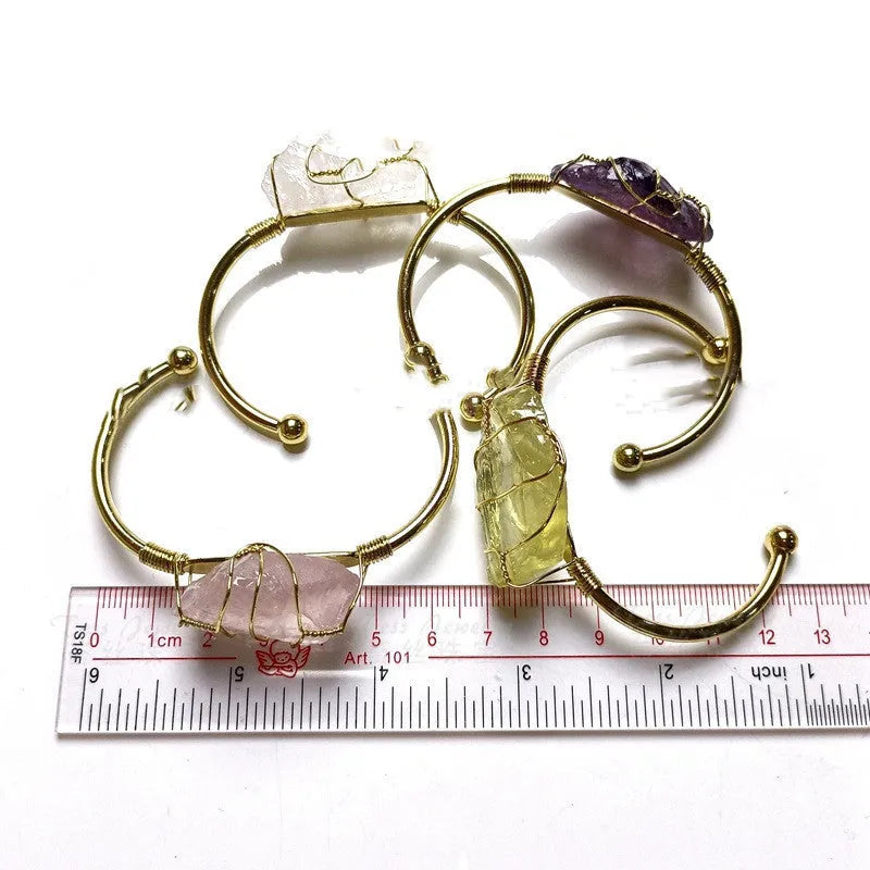 Natural rough crystal bracelet with gold geometric winding on a wrist, showing bohemian style.