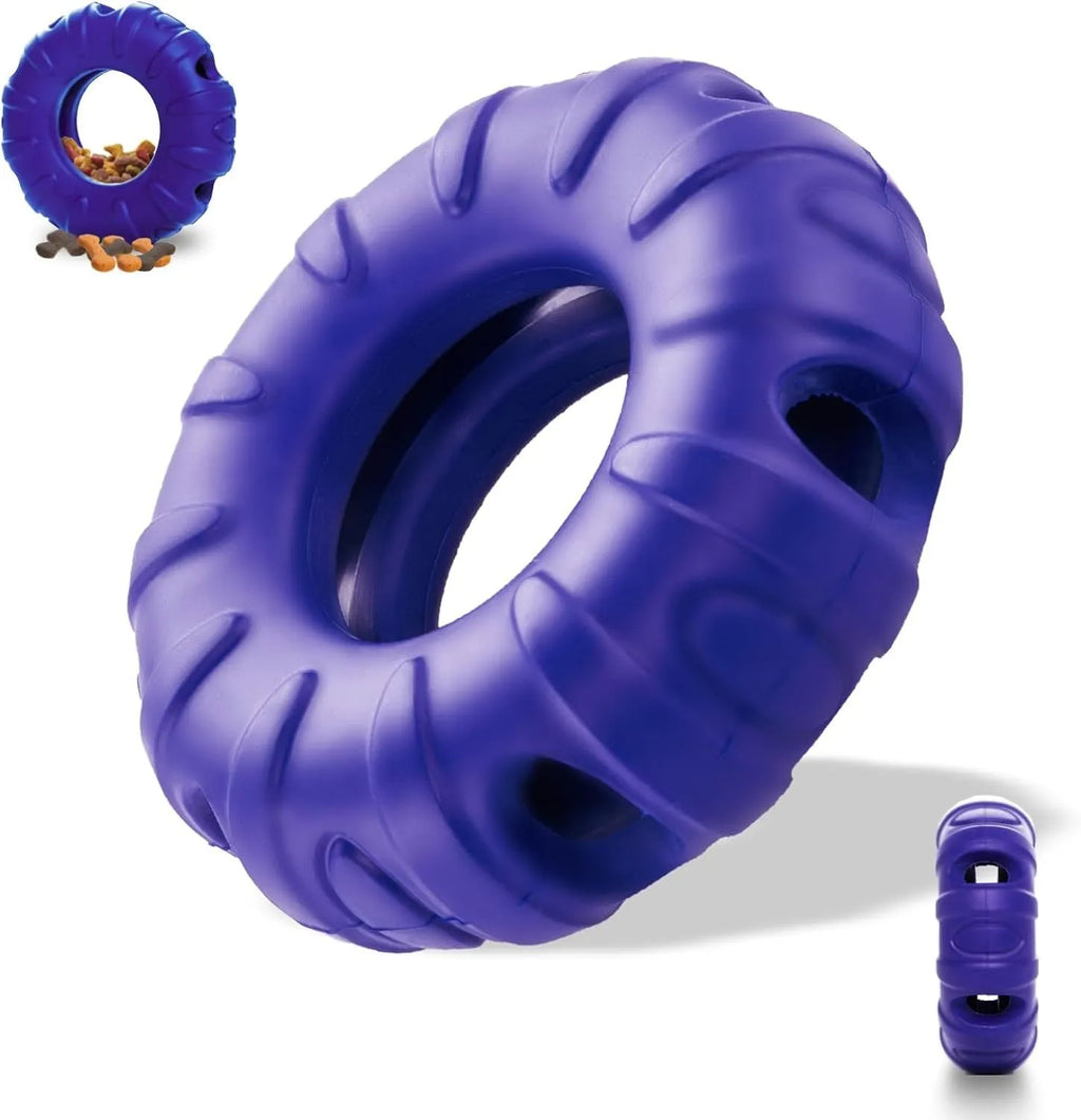 Blue rubber tyre-shaped dog chew toy and slow feeder with oval openings on a wooden floor.